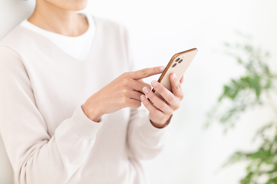 スマートフォンを見る女性（イメージ）