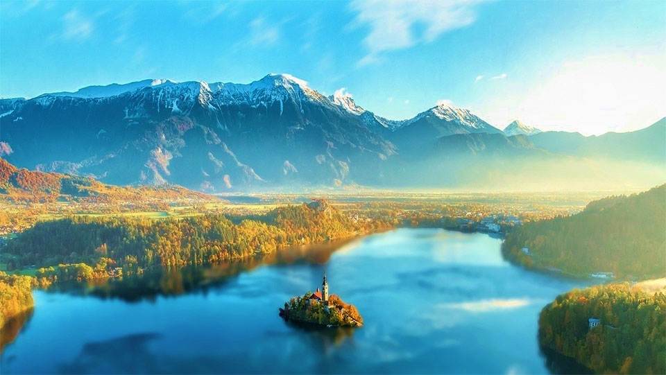 黄葉時期のブレッド湖とユリアンアルプスの絶景（イメージ／黄葉の見頃：例年9月中旬～10月中旬頃）※黄葉の見頃は前後する場合がございます