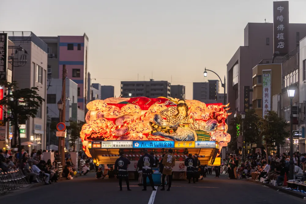 薄暮の中、沿道の観衆に声援を送られながらも、哀愁を感じる送り絵の写真。清姫の心情に寄り添うような一枚は、制作の背景を熟知した写真家ならではの作品です（撮影：成田恭平）